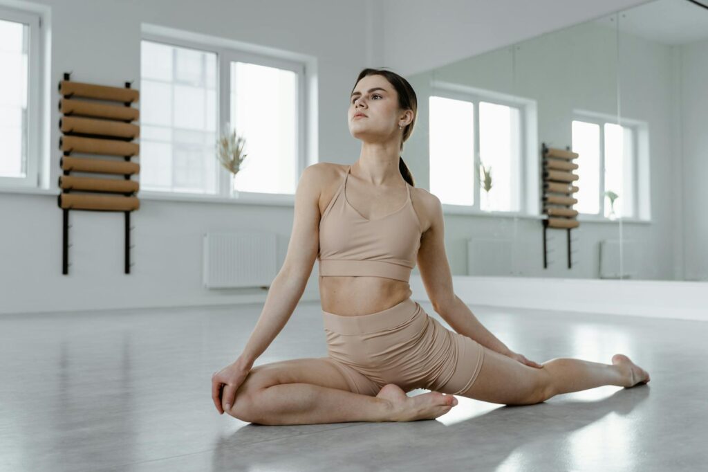 a young woman in a half pigeon yoga pose